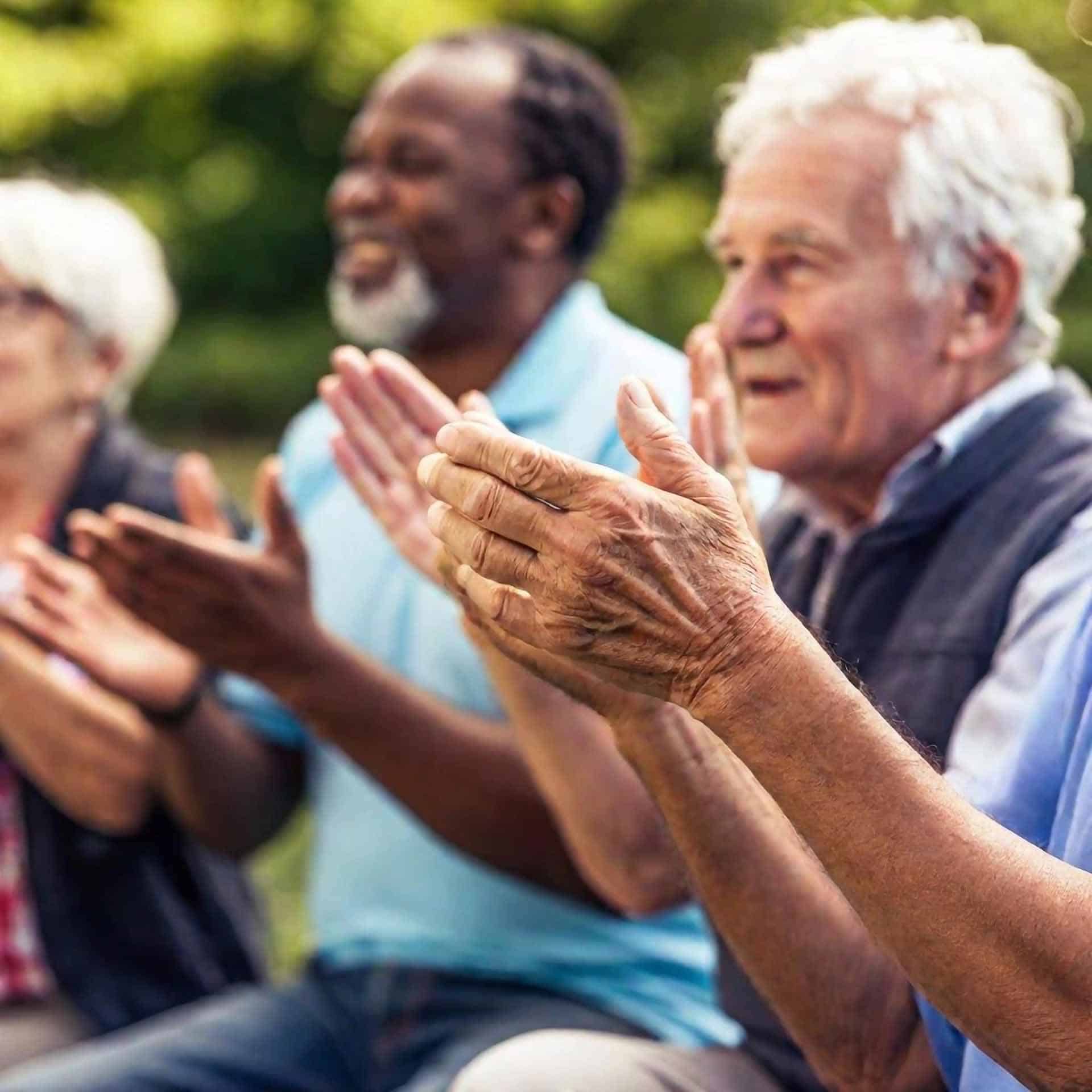 elders clapping as they watch something outside